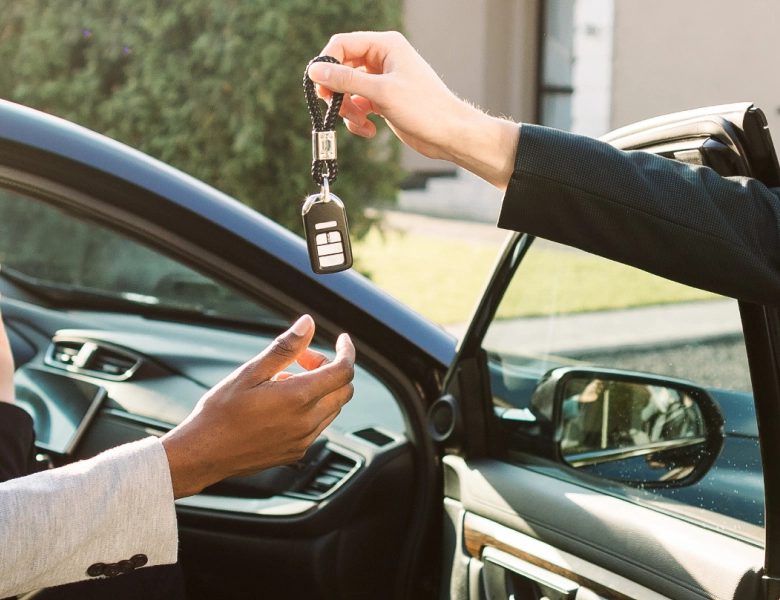 A car key being handed to a customer