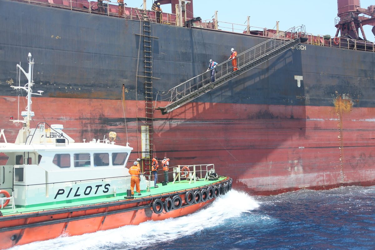 A pilot boat running alongside an incoming vessel