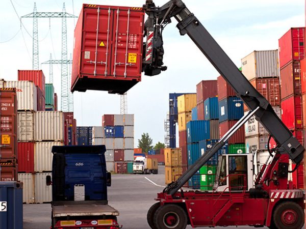 Reach stacker lifting a container at a container freight station