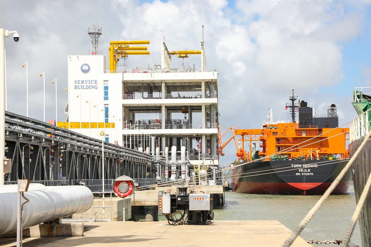 A vessel moored at berth with a tug alongside