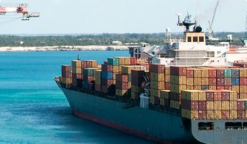 A container ship in turquoise coastal water
