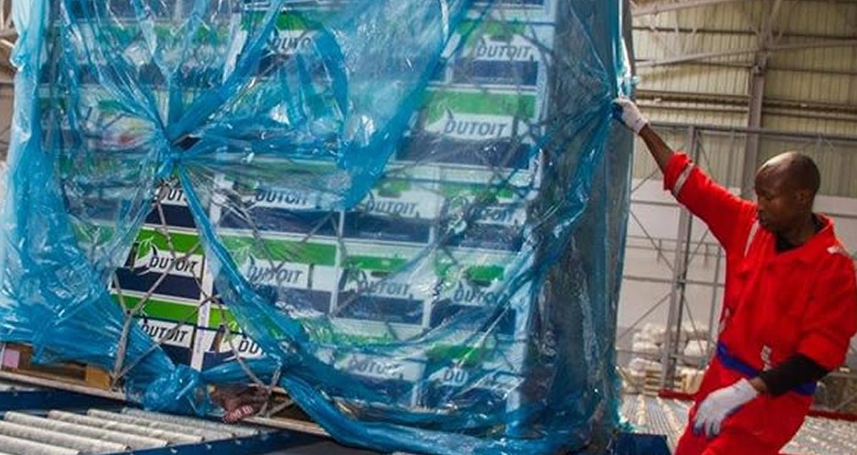 A worker shrink-wrapping an outbound pallet